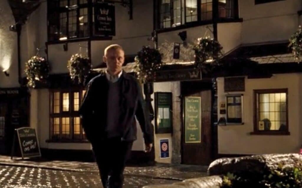 Simon Pegg in a scene outside The Crown At Wells from Hot Fuzz 2007, a comedy action film 